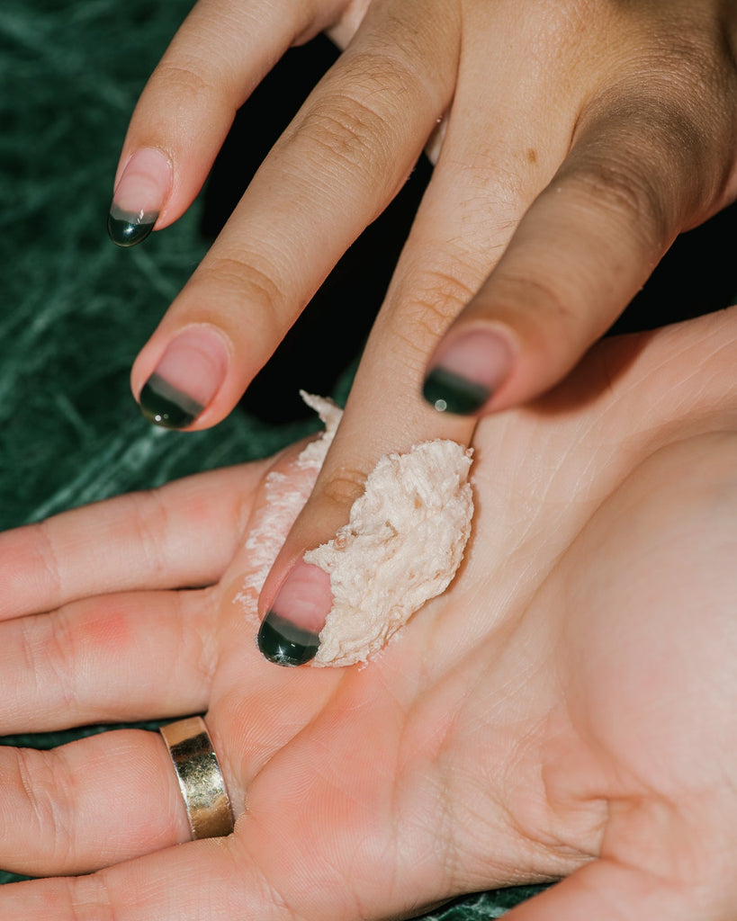 Close up of G.Tox Himalayan Salt Scrub Shampoo on hand.