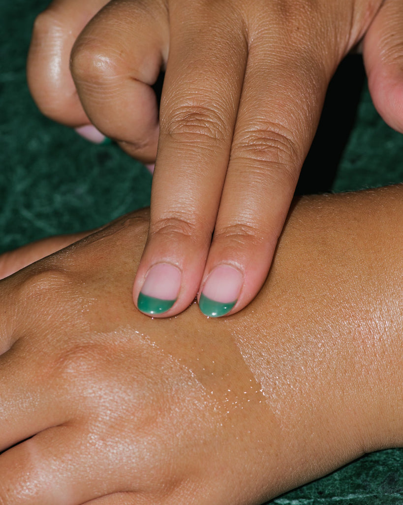 Close up of Hinoki Body Oil on hand.